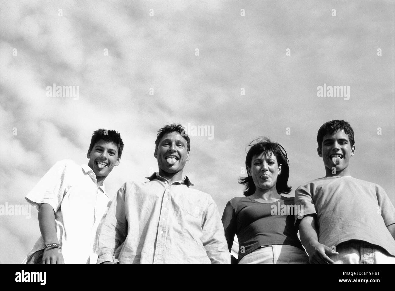 Family sticking out tongues at camera, low angle view Stock Photo