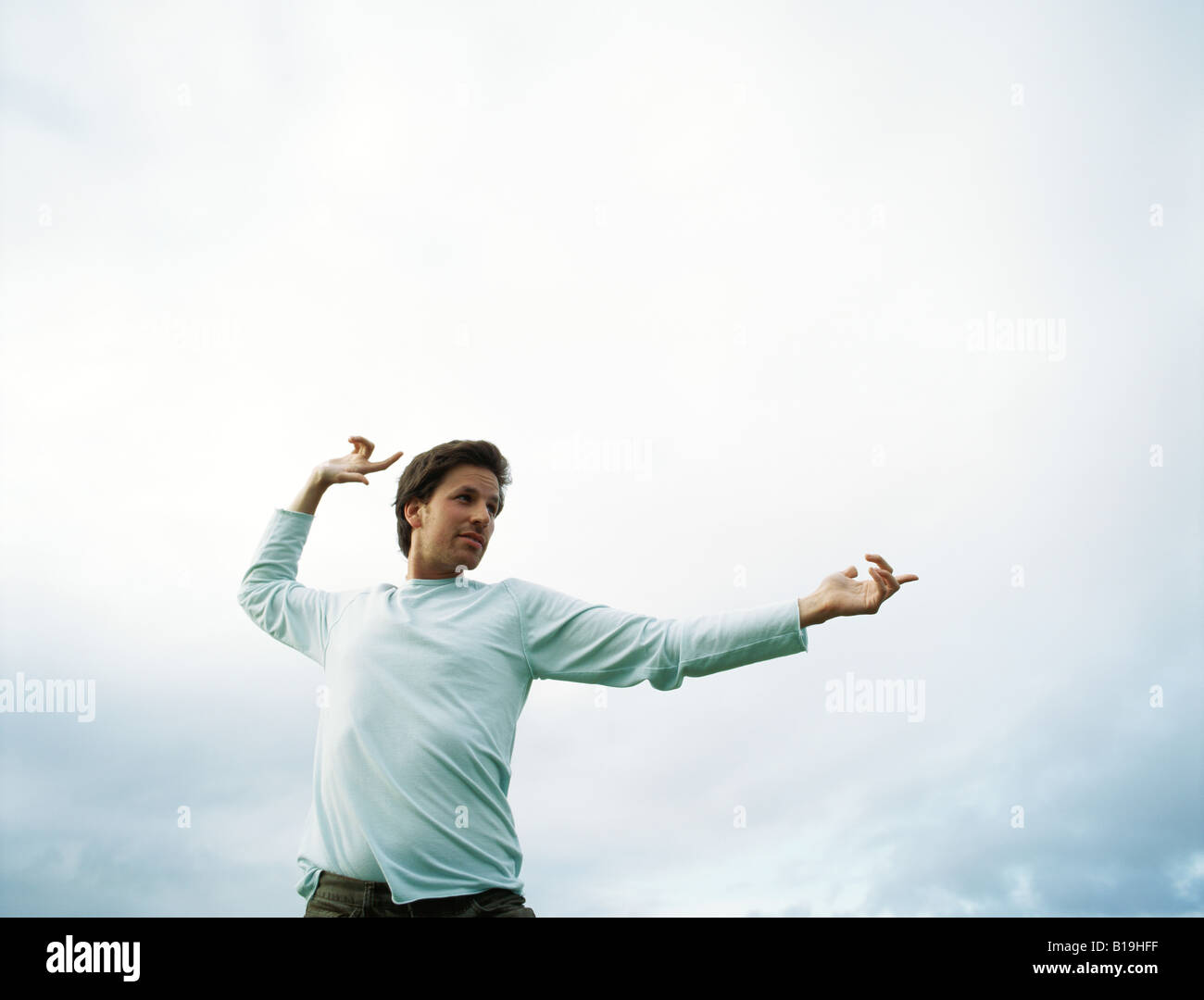 Man standing outdoors, gesticulating, low angle view Stock Photo