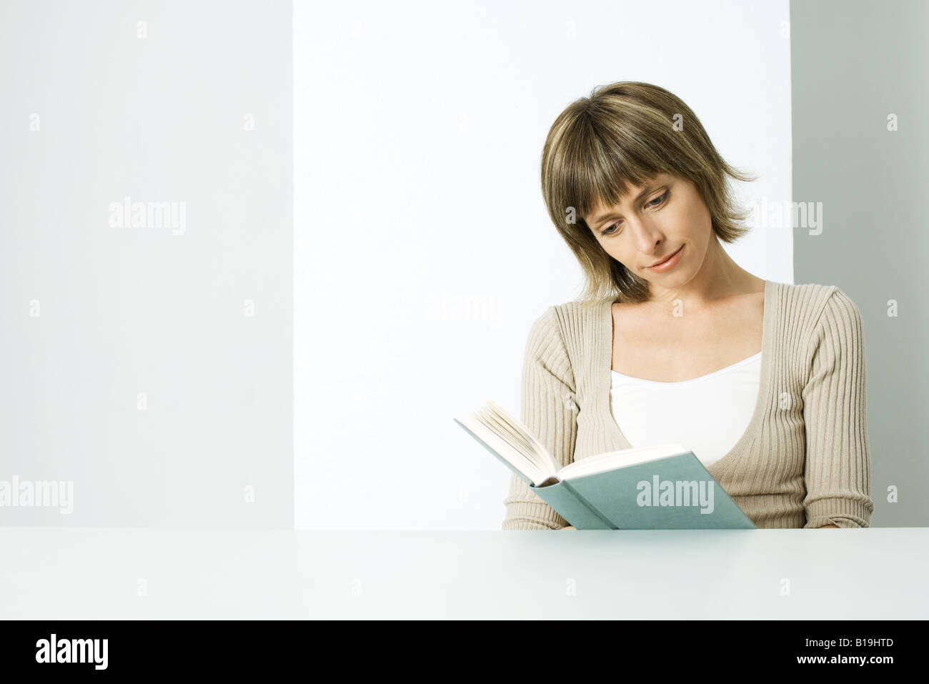 Woman sitting, reading book Stock Photo