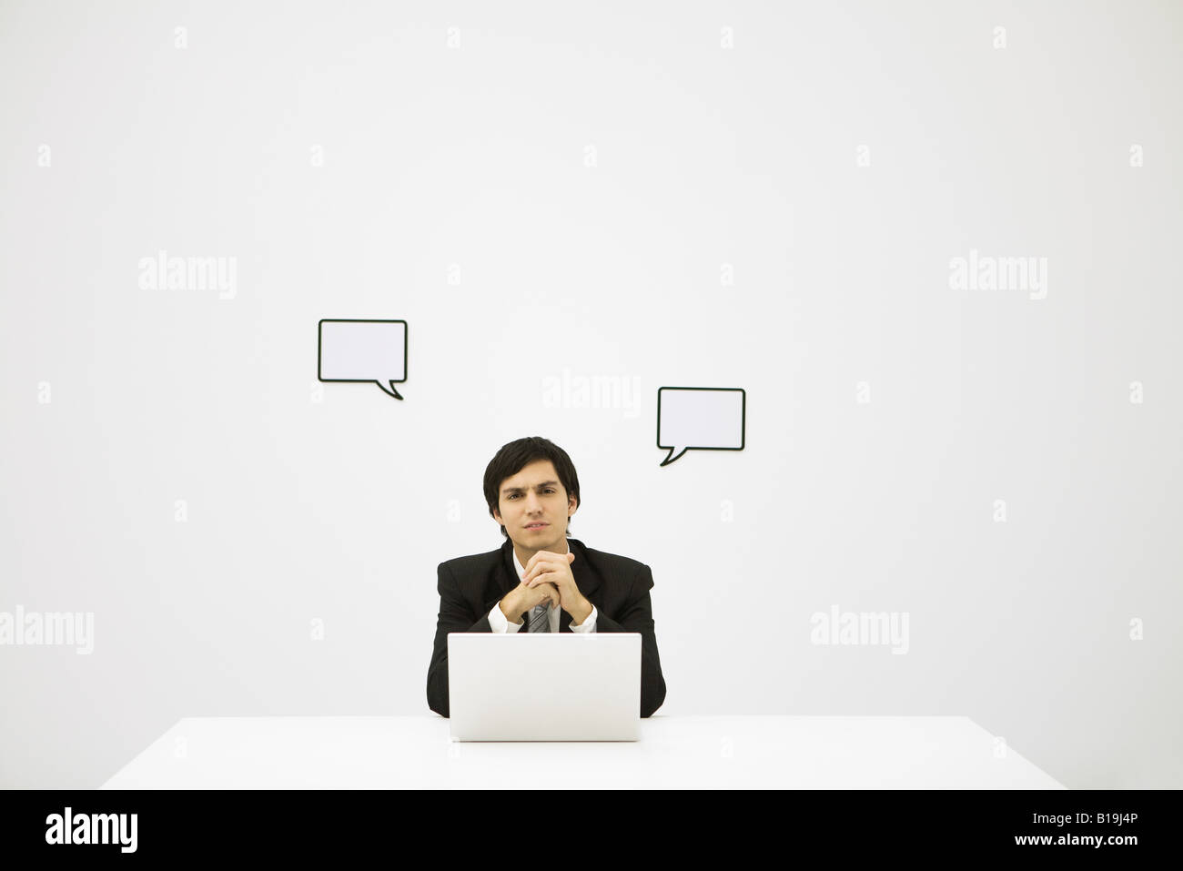 Businessman and word bubbles, looking at camera Stock Photo