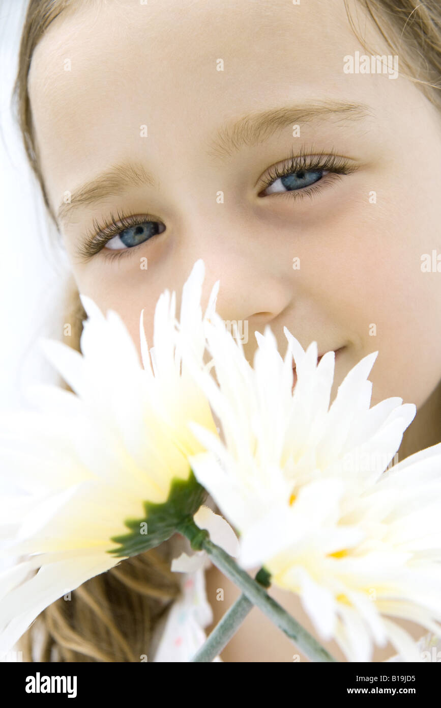 Girl smelling flowers, looking at camera, portrait Stock Photo - Alamy