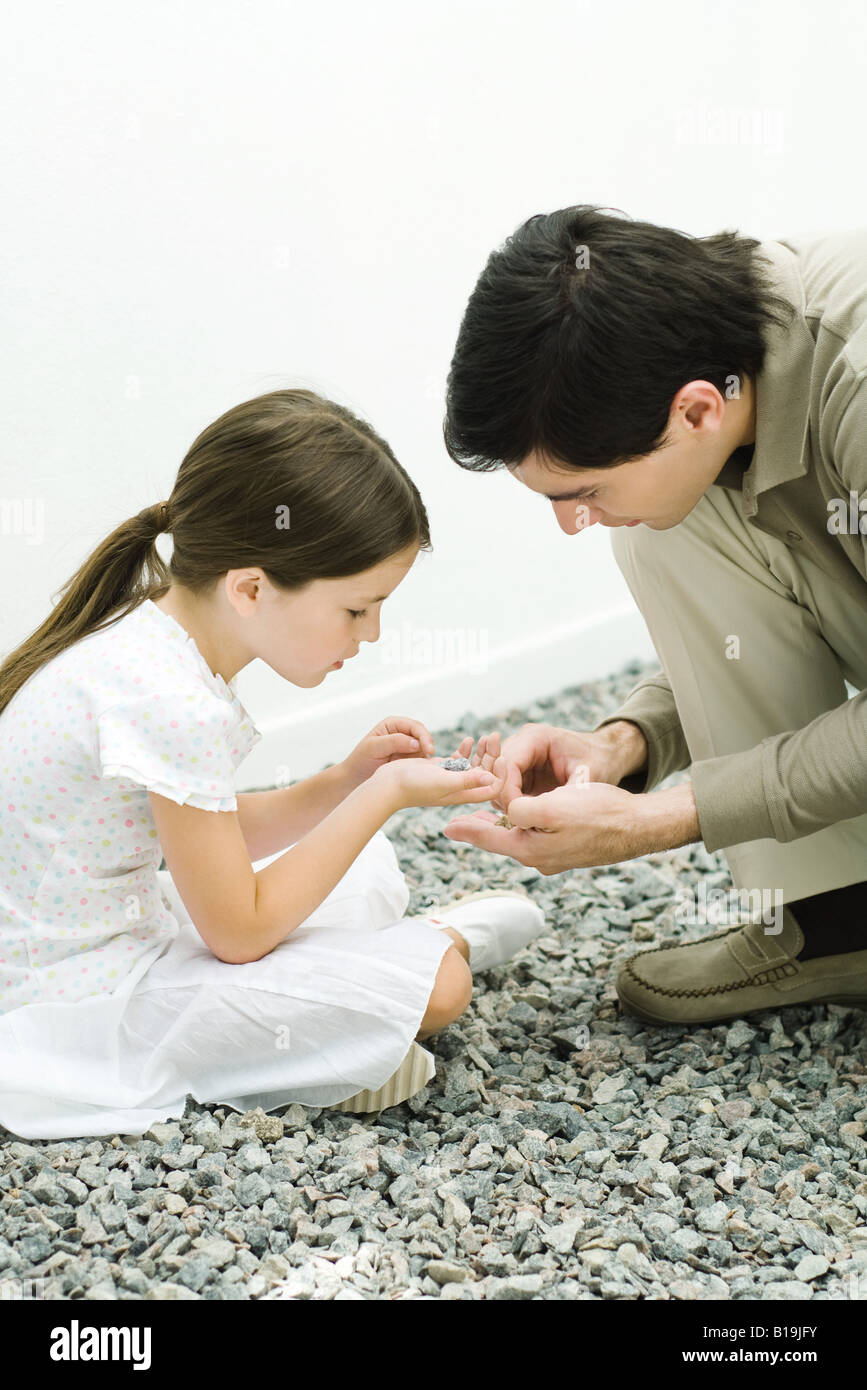Father and daughter looking at gravel together Stock Photo
