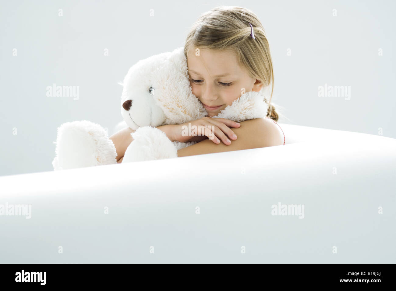 Girl holding teddy bear, smiling, looking down Stock Photo - Alamy