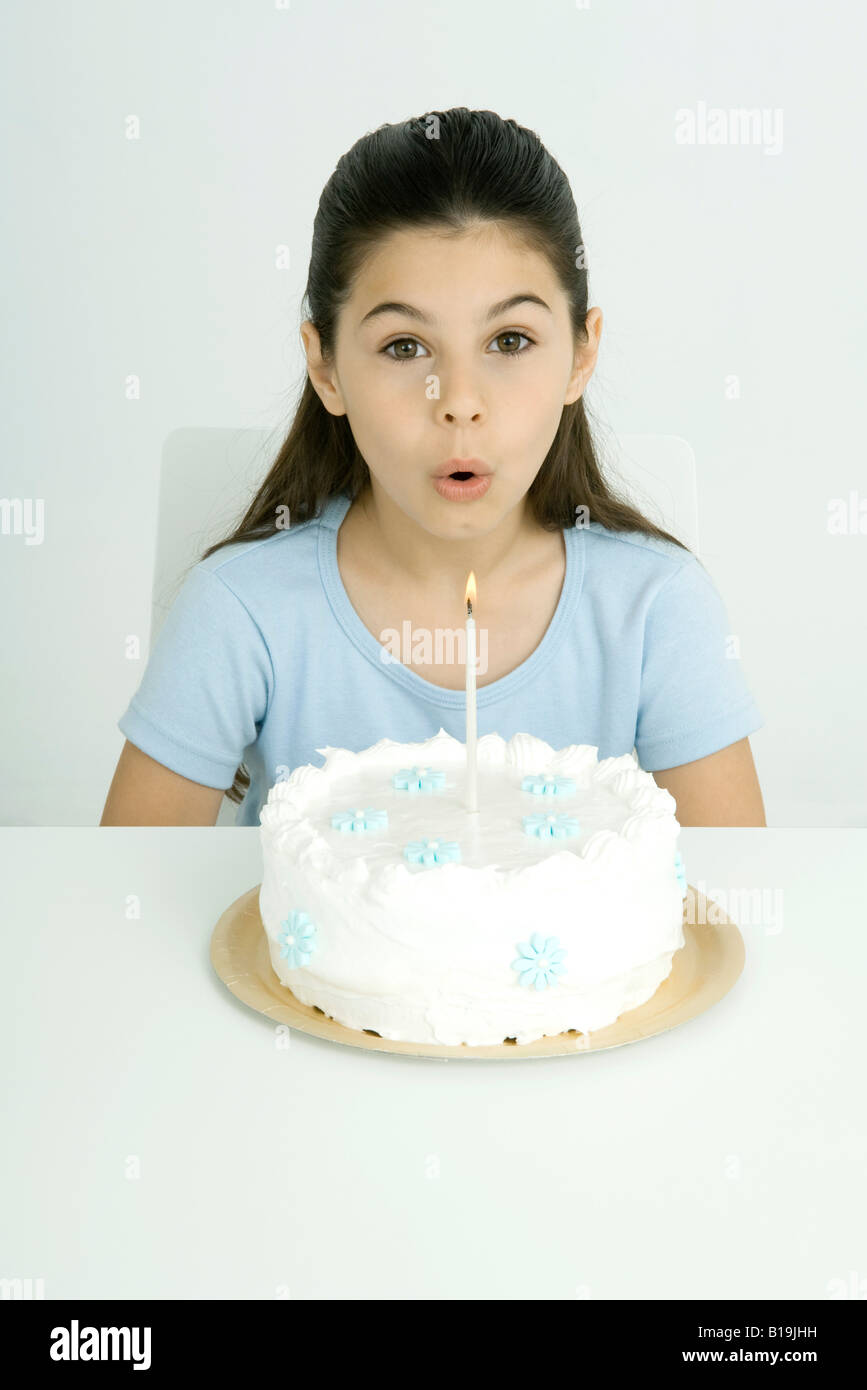 Girl blowing out candle on birthday cake, portrait Stock Photo