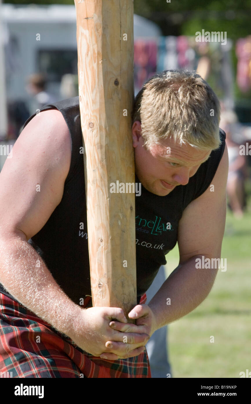 Bruce Robb strong man, athlete, athletic, caber toss, clan, clothing, competition; Scotsman Tossing the Caber, Strathmore Highland Games Scotland, UK Stock Photo