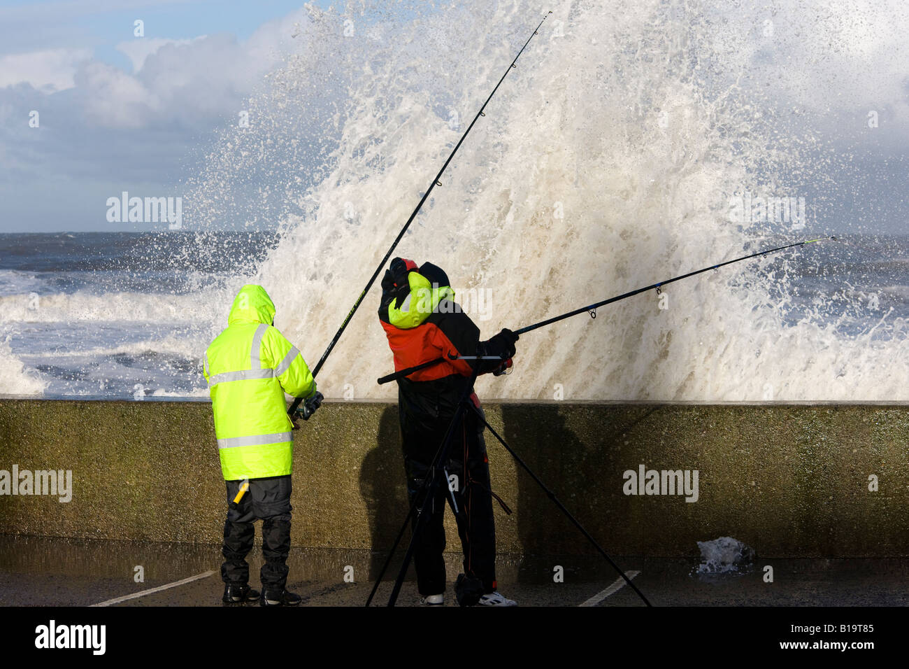 Fishermen caught by wave Sandsend near Whitby North Yorkshire Stock Photo