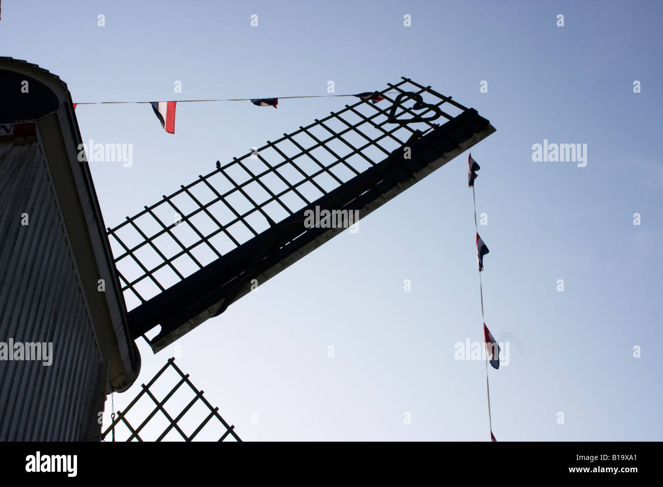 Detail of a wooden dutch windmill decorated with a line of dutch flags ...