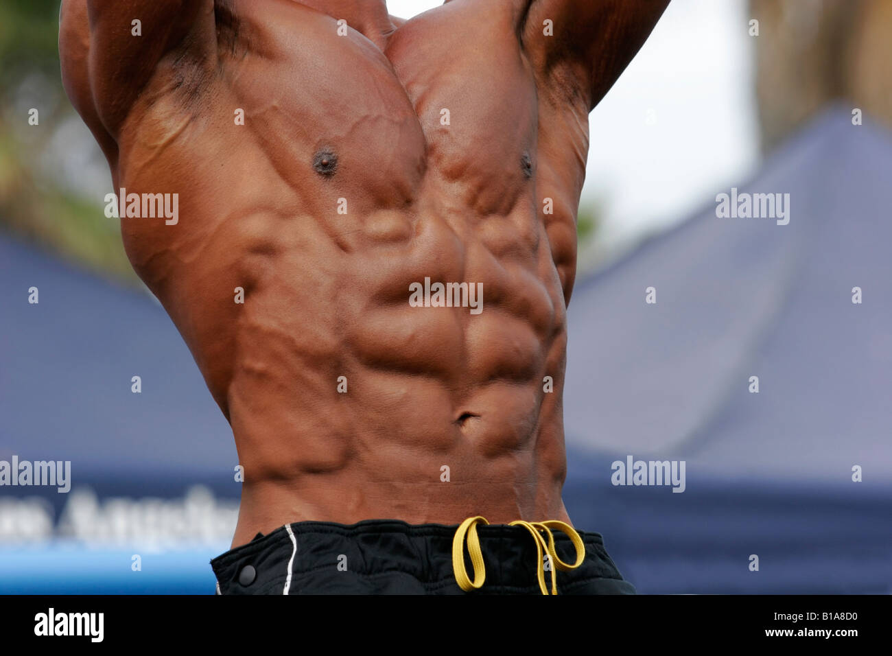 Bodybuilder flexing his abdominal muscles during a workout at an outdoor  gym Stock Photo - Alamy