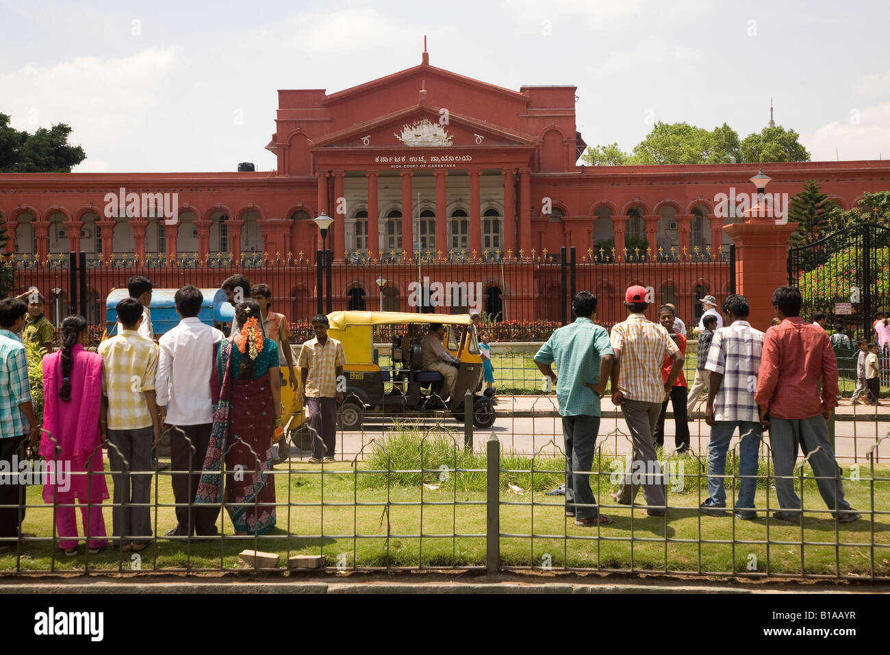 People enjoy posing and taking photographs on grass near the Attara Kacheri, the state high court in Bangalore, India. Stock Photo