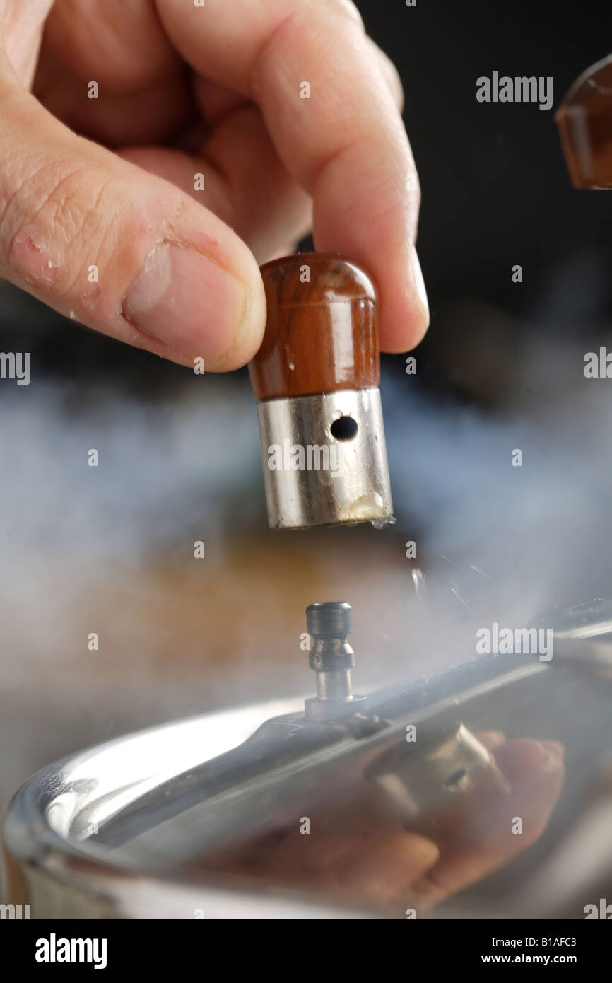 Removing the pressure cooker stopper (vertical) Stock Photo