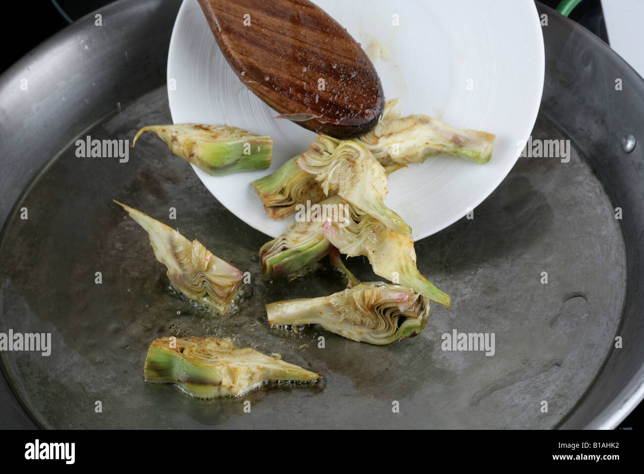 Frying artichokes in paella pan Stock Photo Alamy