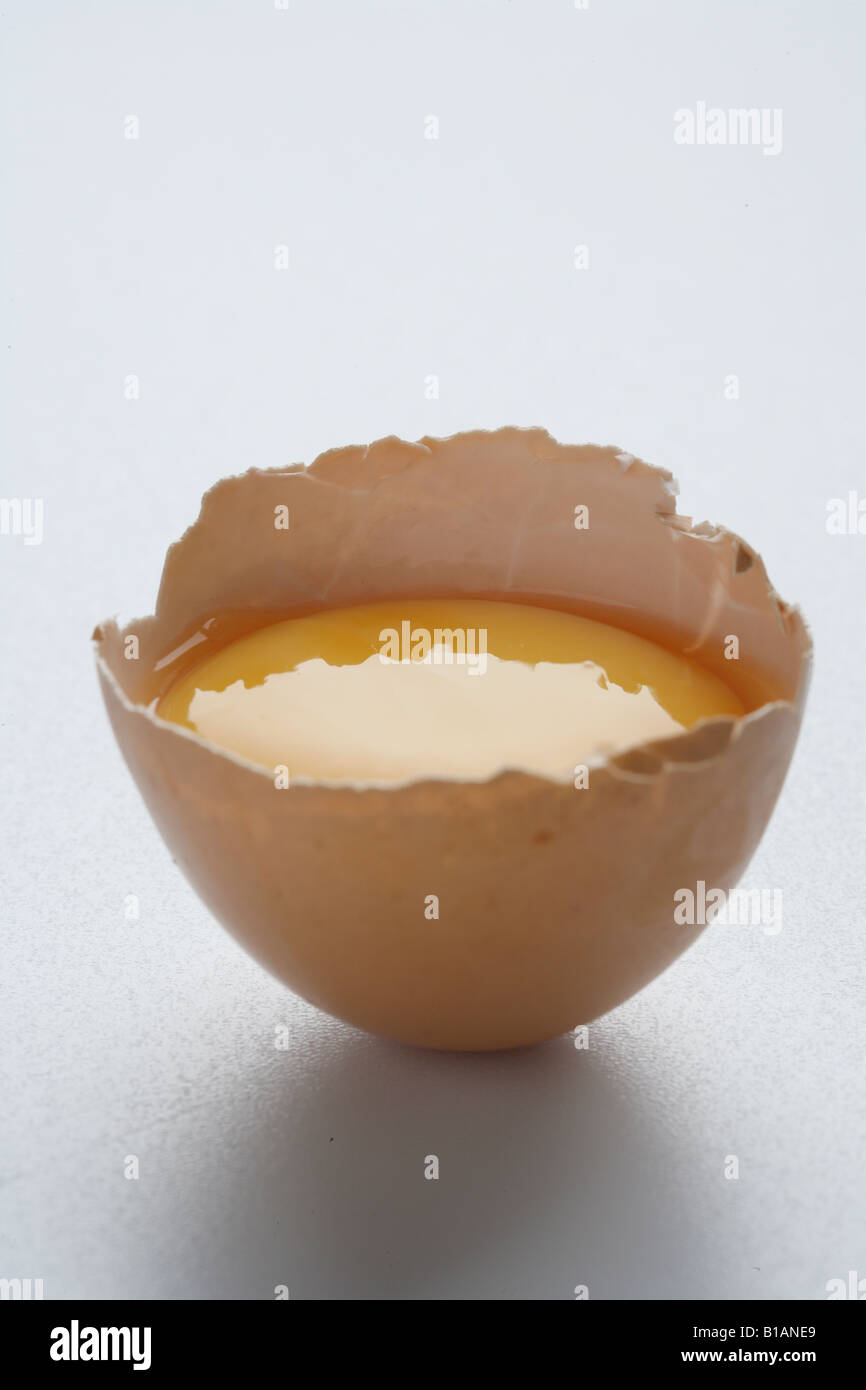 Half of a broken egg with the yolk inside Stock Photo
