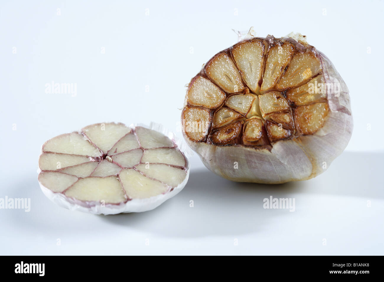 Cut head of garlic, one half roasted Stock Photo Alamy