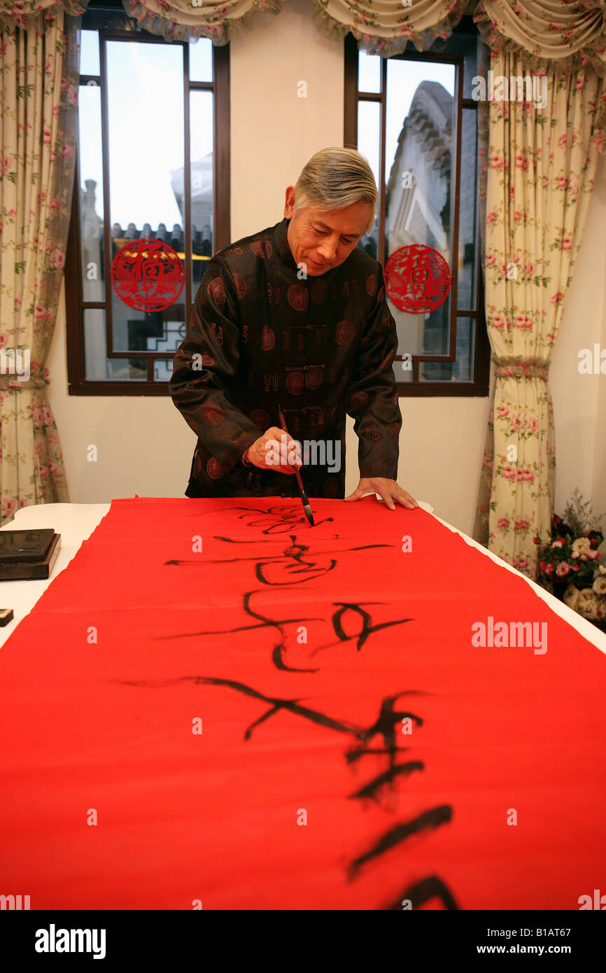 Chinese mature man writing chinese script with brushpen Stock Photo