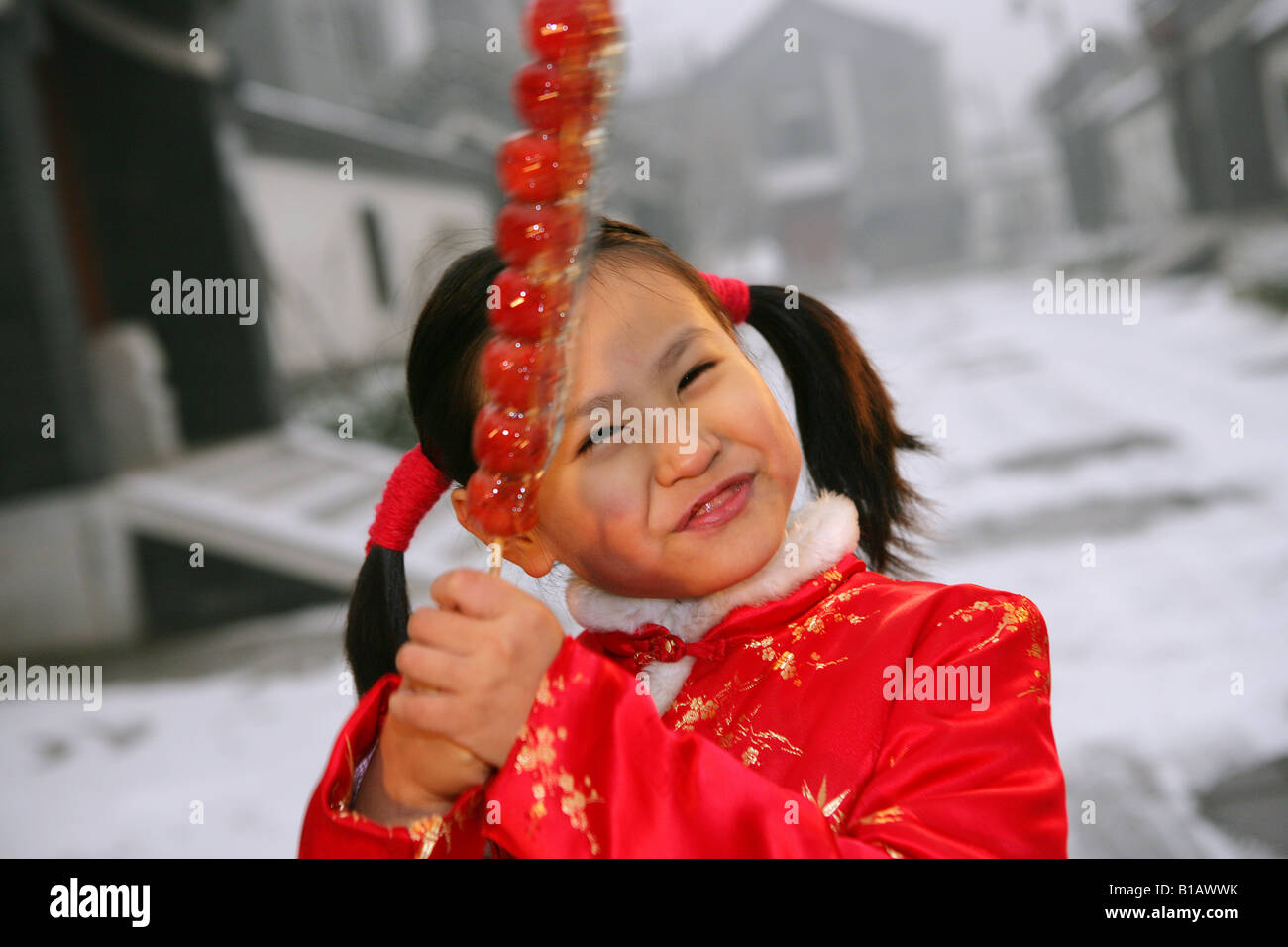 one chinese girl holding a sugar-coated haws thinking Stock Photo