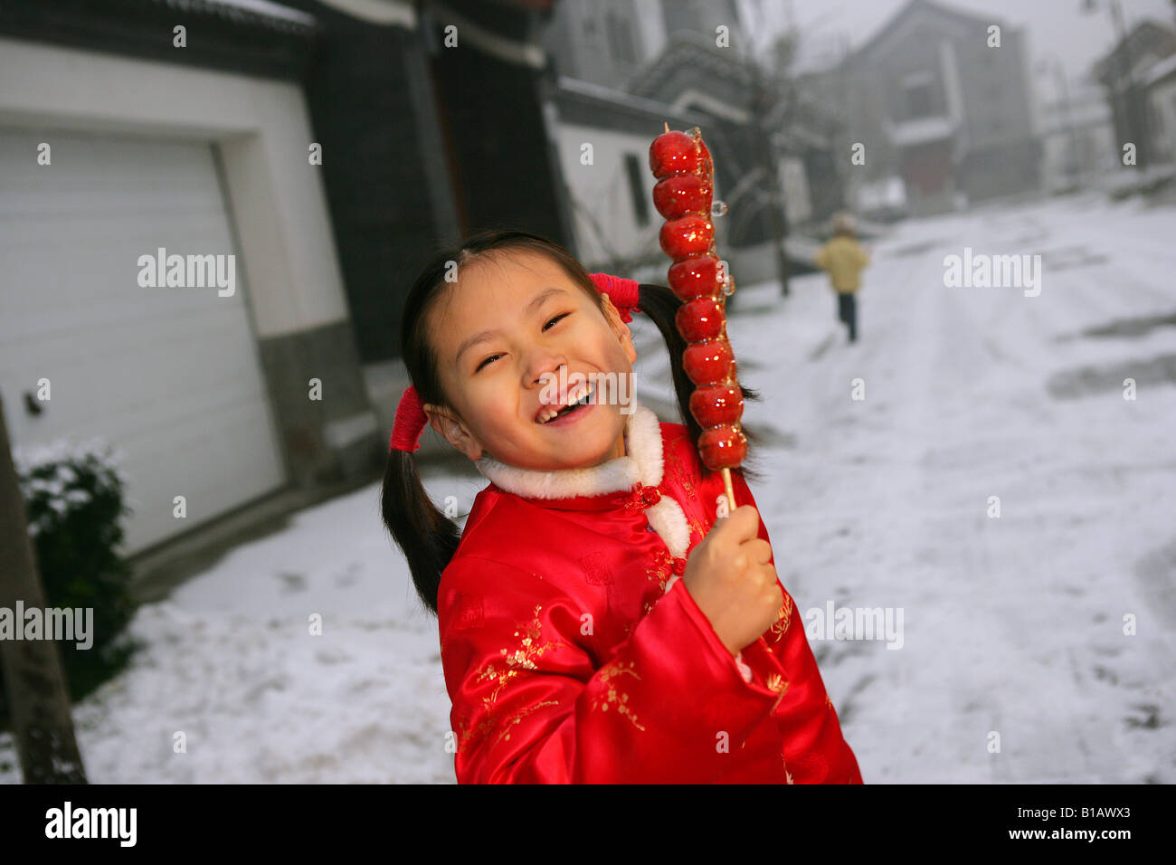 one chinese girl dressed in traditional clothing holding candied haws Stock Photo