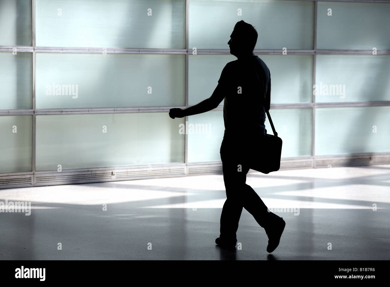 Silhouette of a walking man with a bag Stock Photo - Alamy