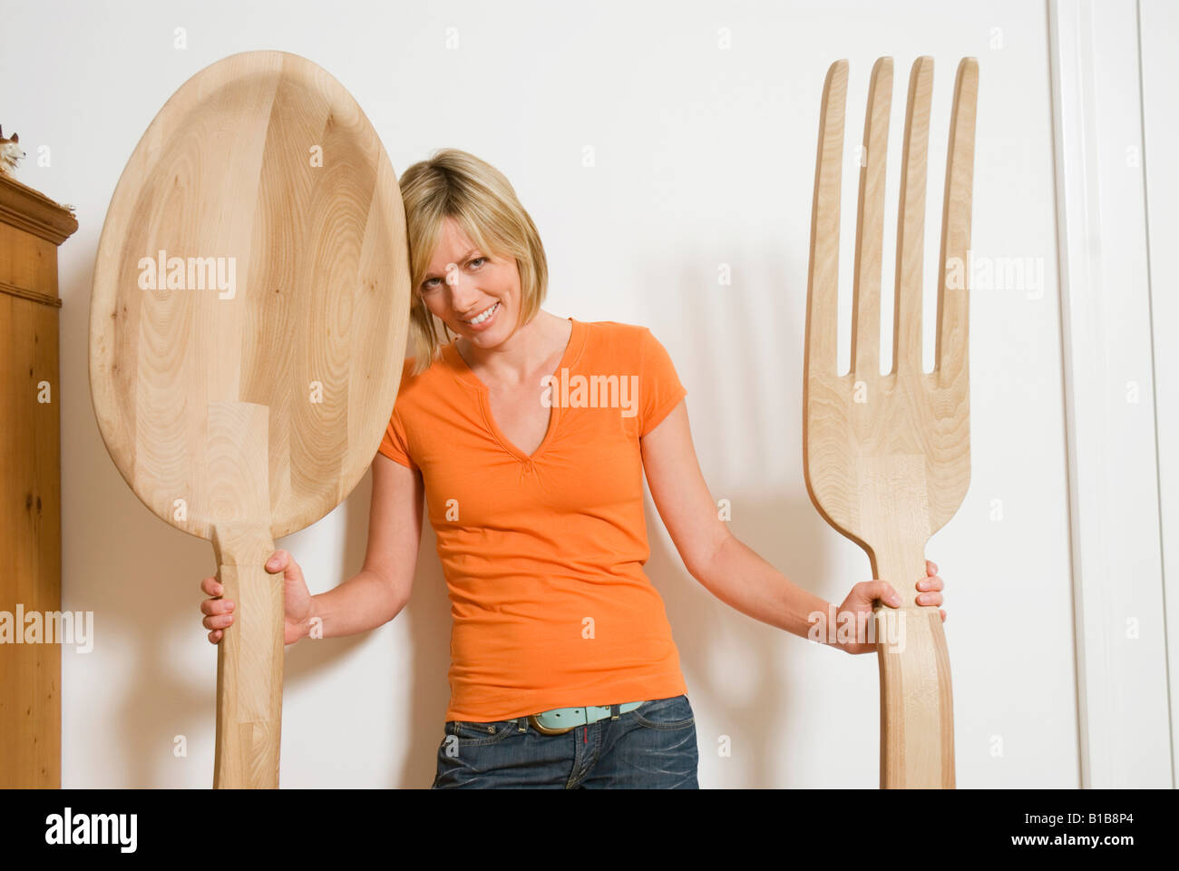 Woman holding giant cutlery in hands, close-up Stock Photo