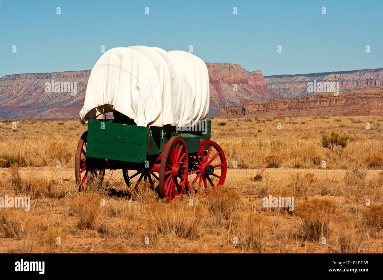 An antique wooden wagon from the wild west with red wheels. Stock Photo