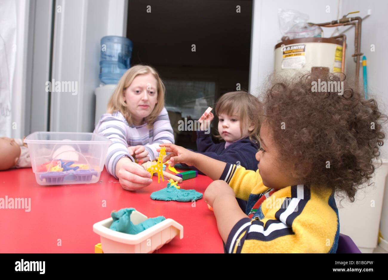 Preschool kids playing with teacher Stock Photo - Alamy