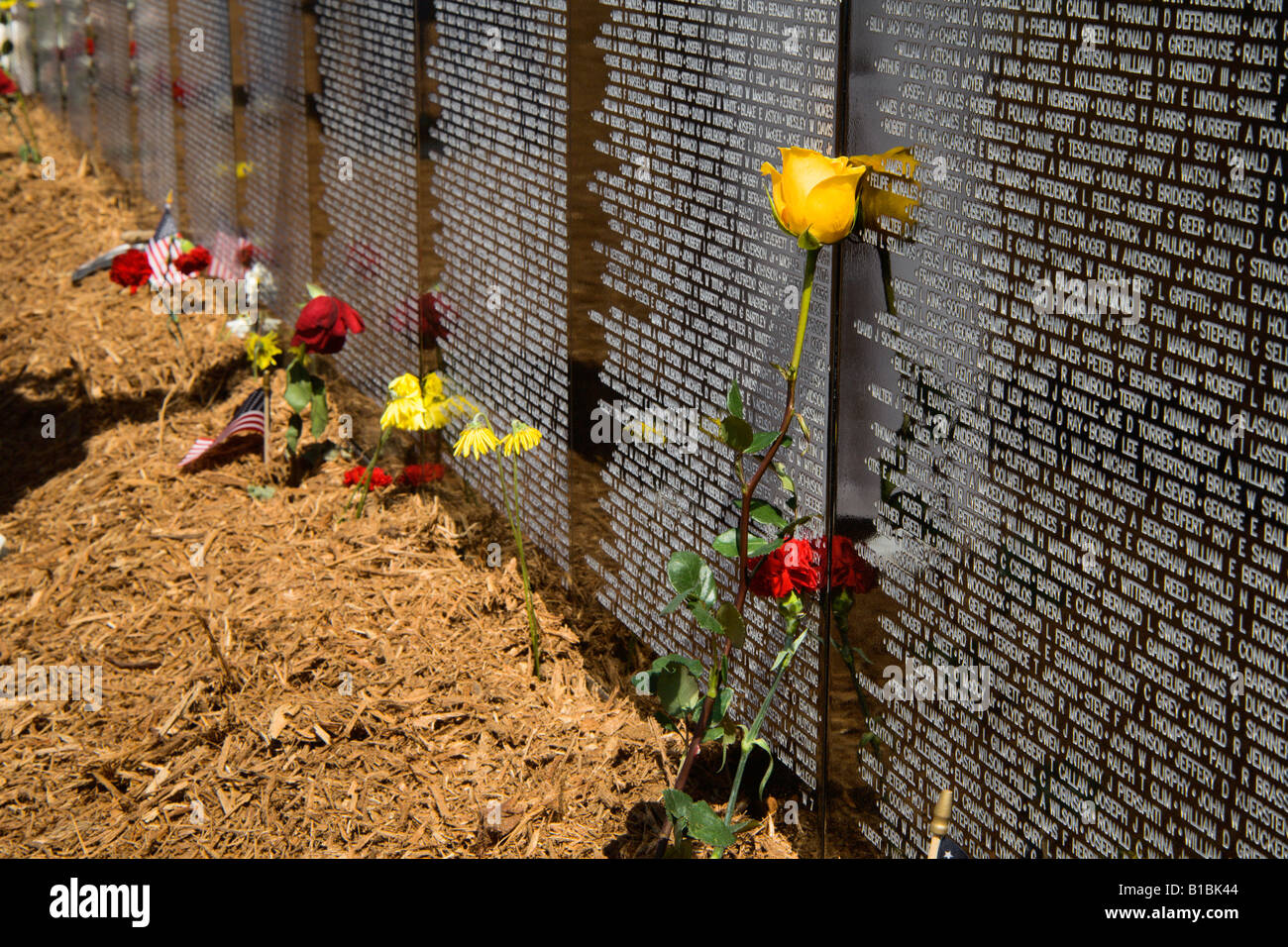 Flowers left at the base of the Vietnam traveling memorial wall Stock Photo