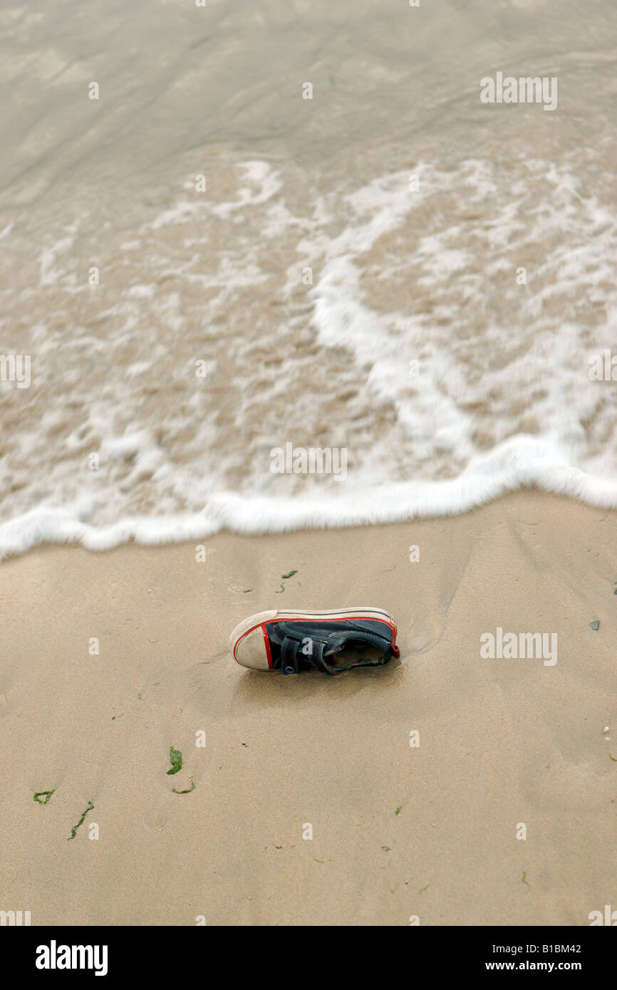 Old canvas shoe washed up on shore Stock Photo Alamy