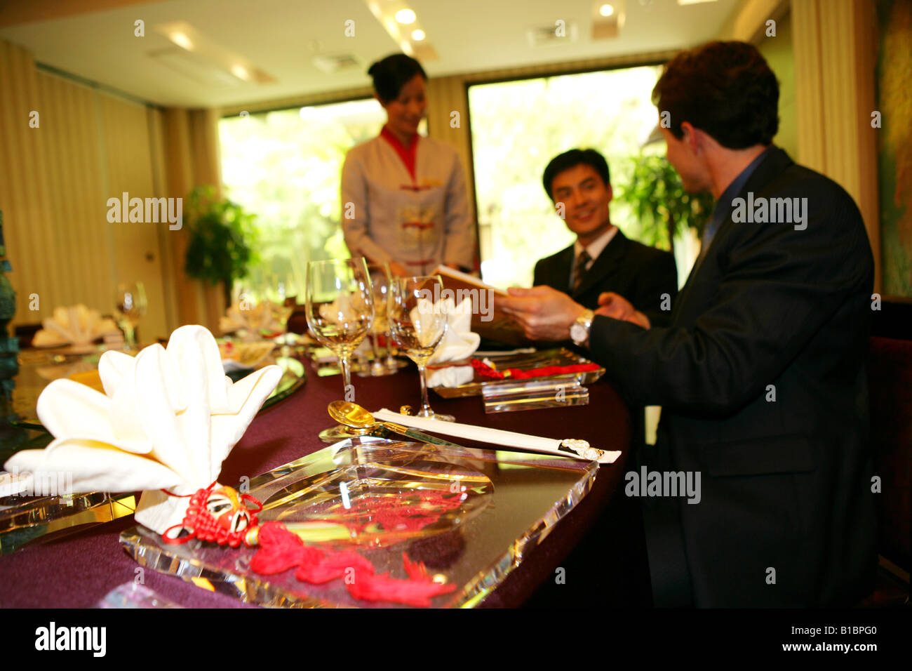 businessmen and businesswoman ordering in hotel restaurant Stock Photo