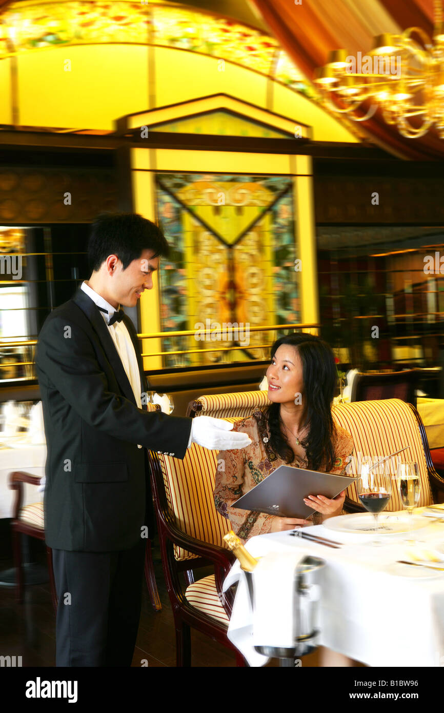 hotel waiter introducing menu for guest Stock Photo - Alamy