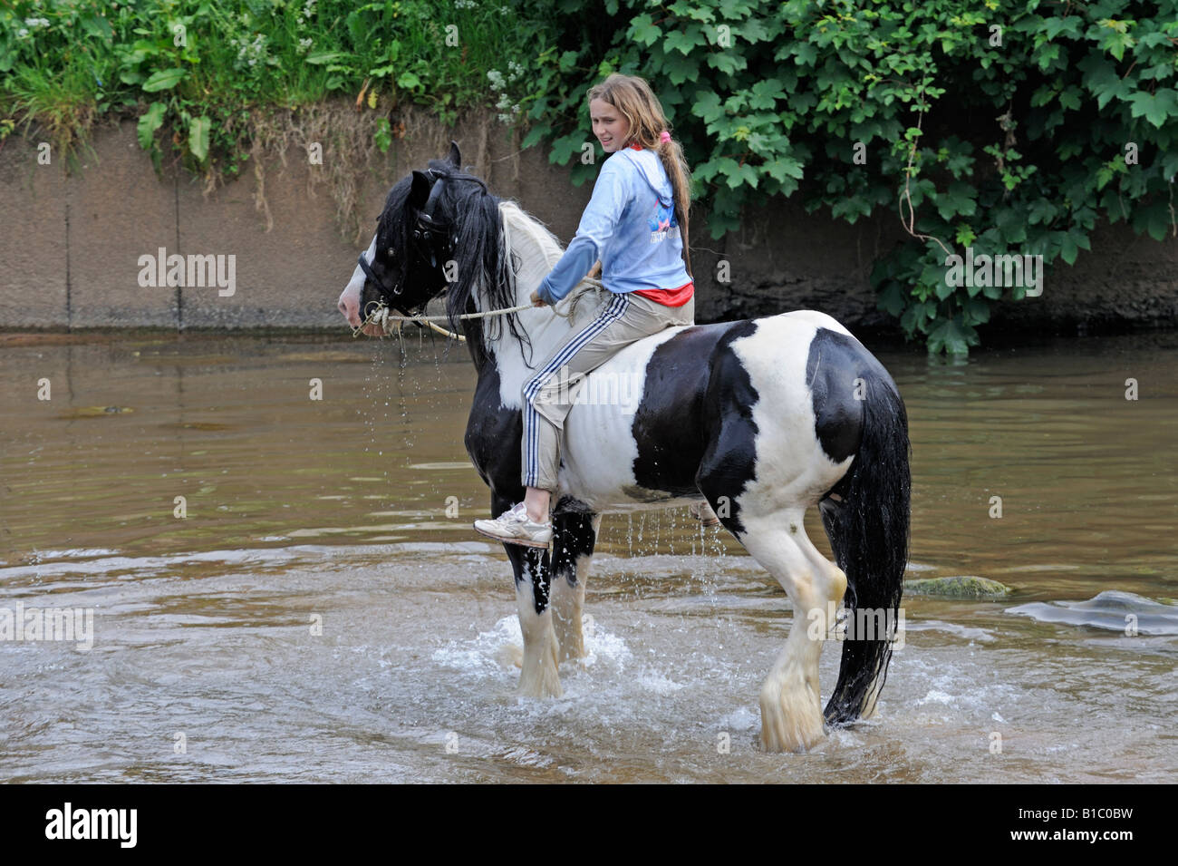Gypsy traveller girl riding horse in River Eden. Appleby Horse Fair. Appleby-in-Westmorland, Cumbria, England, United Kingdom. Stock Photo