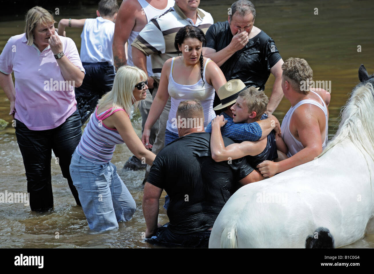 Gypsy traveller boy being rescued from drowning in River Eden. Appleby Horse Fair. Appleby-in-Westmorland, Cumbria, England. Stock Photo