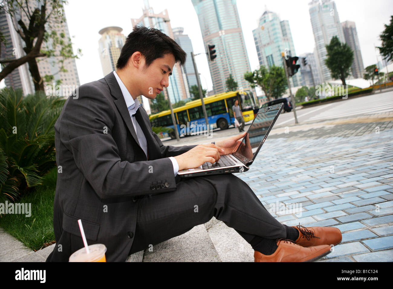one businessman using laptop outside an office building in Pudong