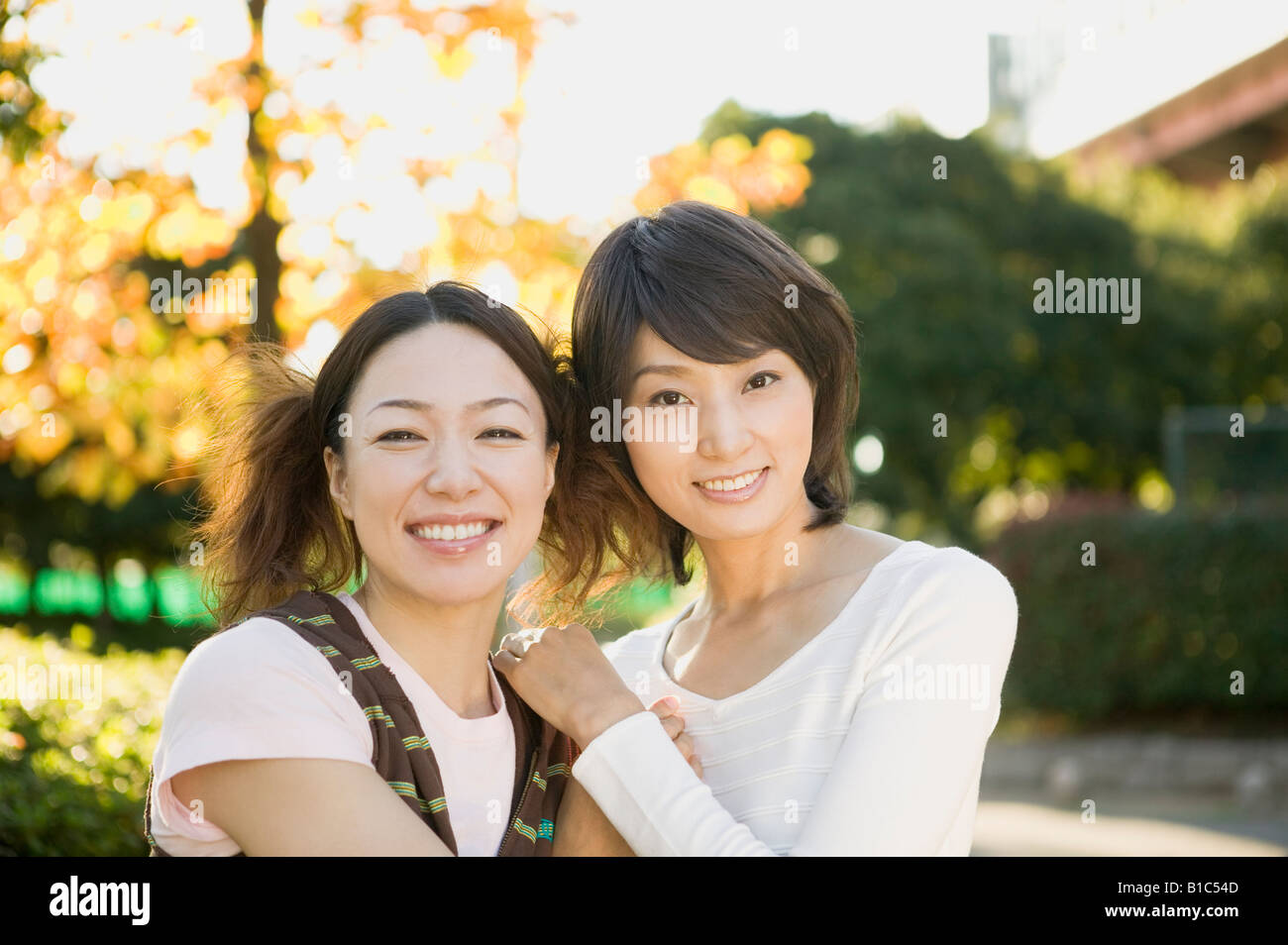 Portrait of two young women smiling Stock Photo - Alamy