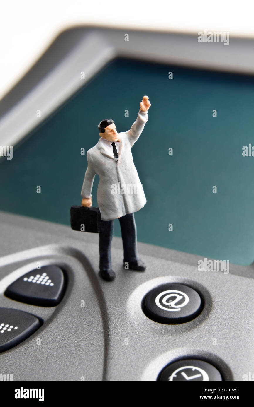 Businessman figurine standing on a PDA Stock Photo