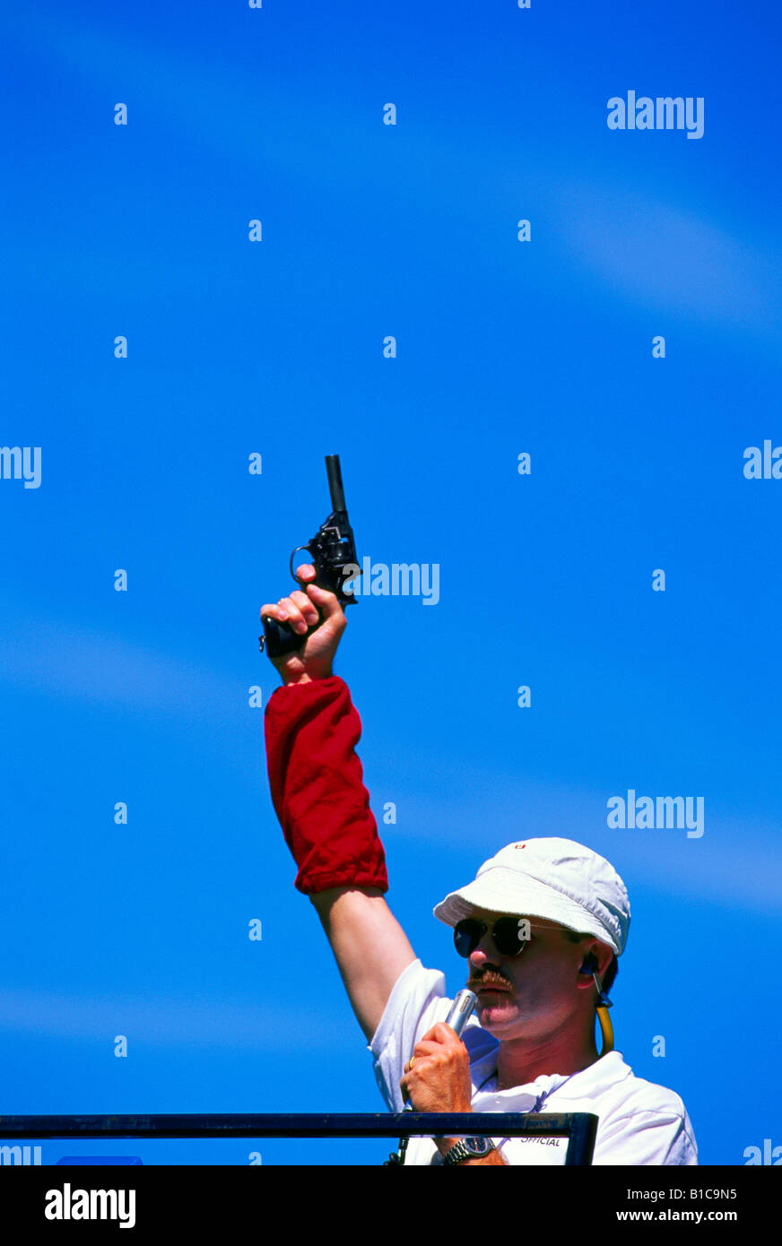 Ready Set Go - Sports Official holding Starter Pistol at Starting Line of Track and Field Race Stock Photo