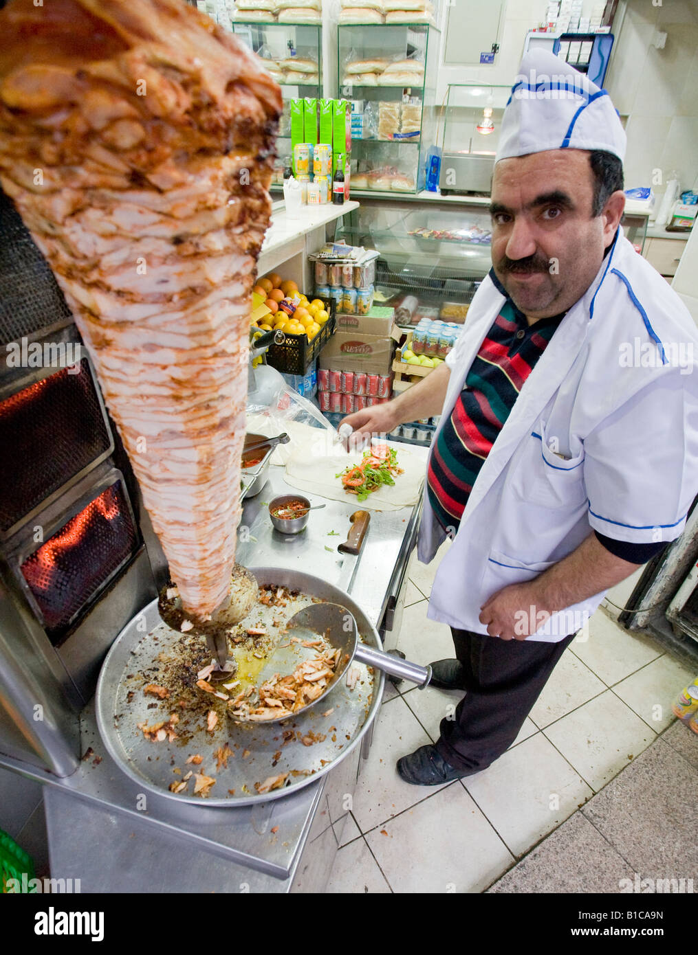 A little Salt Perhaps? A Donar being prepared with the meat in the foreground and a pida with salid in the background Stock Photo