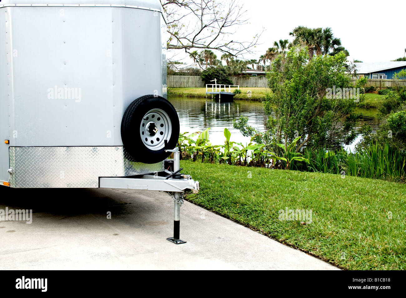 Photo of trailer hitch with spare tire not connected by a small pond Stock Photo