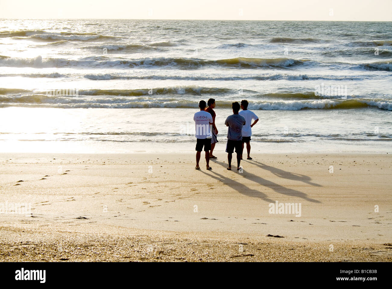 Photo of four young Asian men standing on the beach by the ocean in Ponte Vedra Beach, Florida Stock Photo