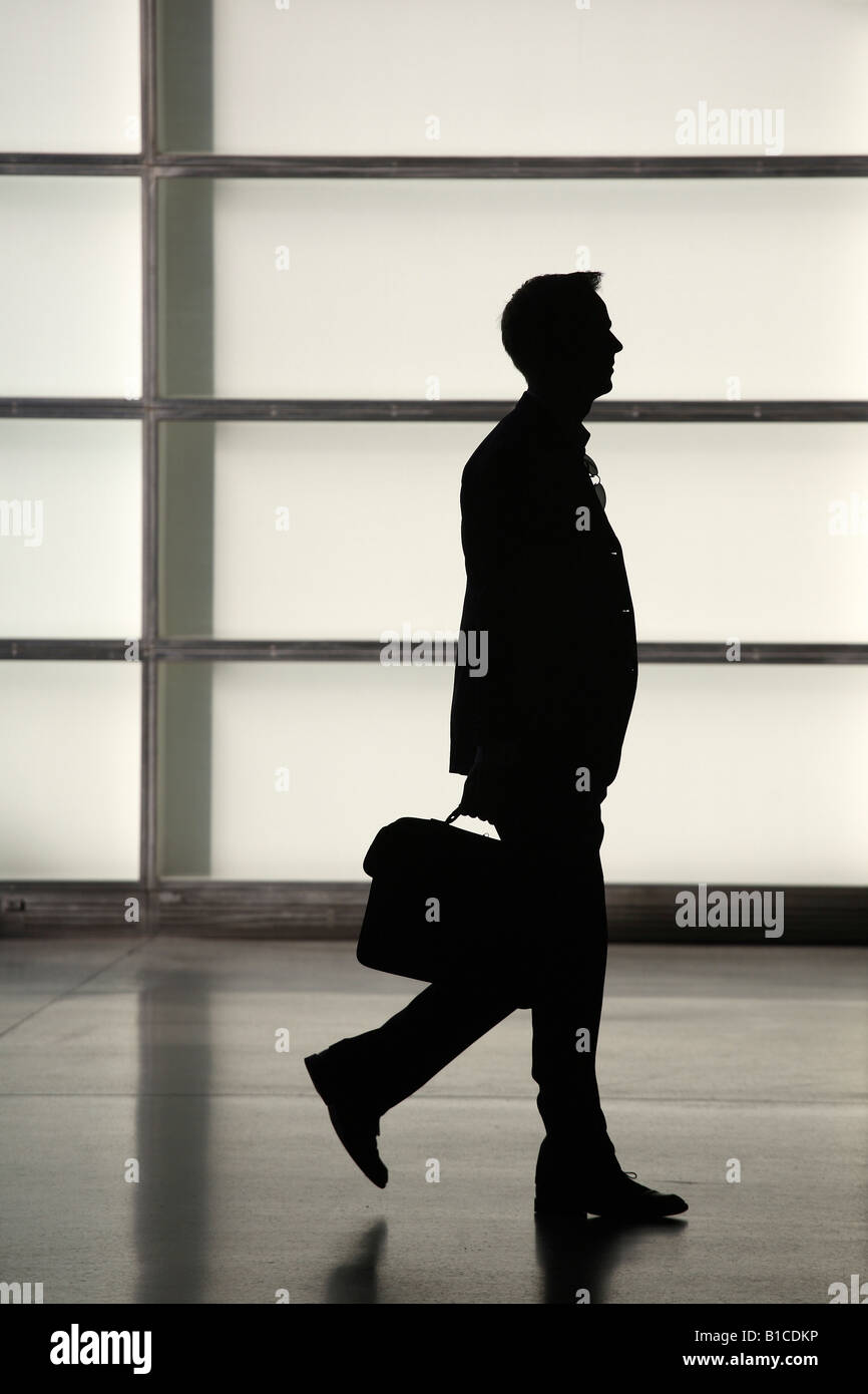 Silhouette of a walking man with a briefcase Stock Photo - Alamy