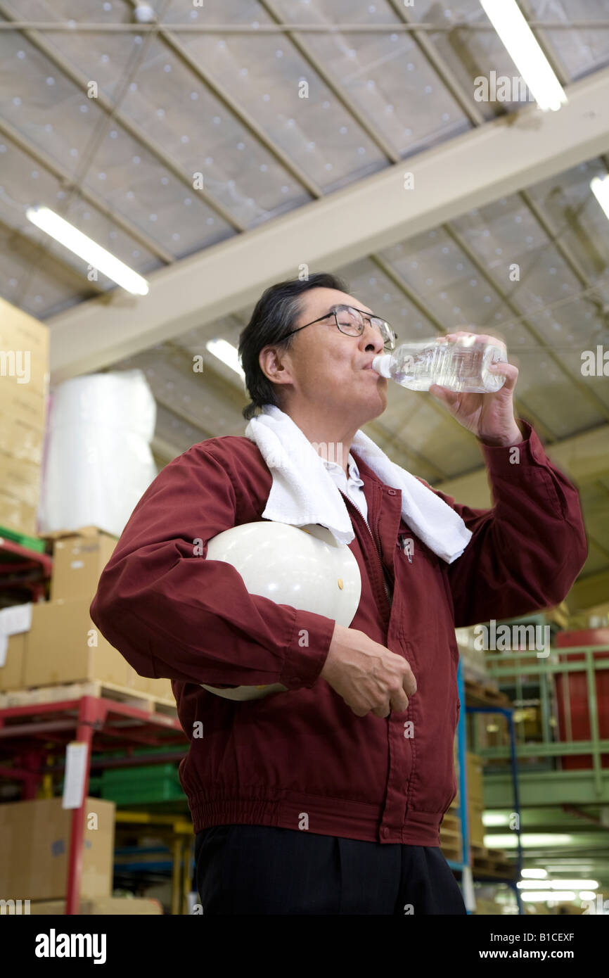 Senior worker drinking water Stock Photo