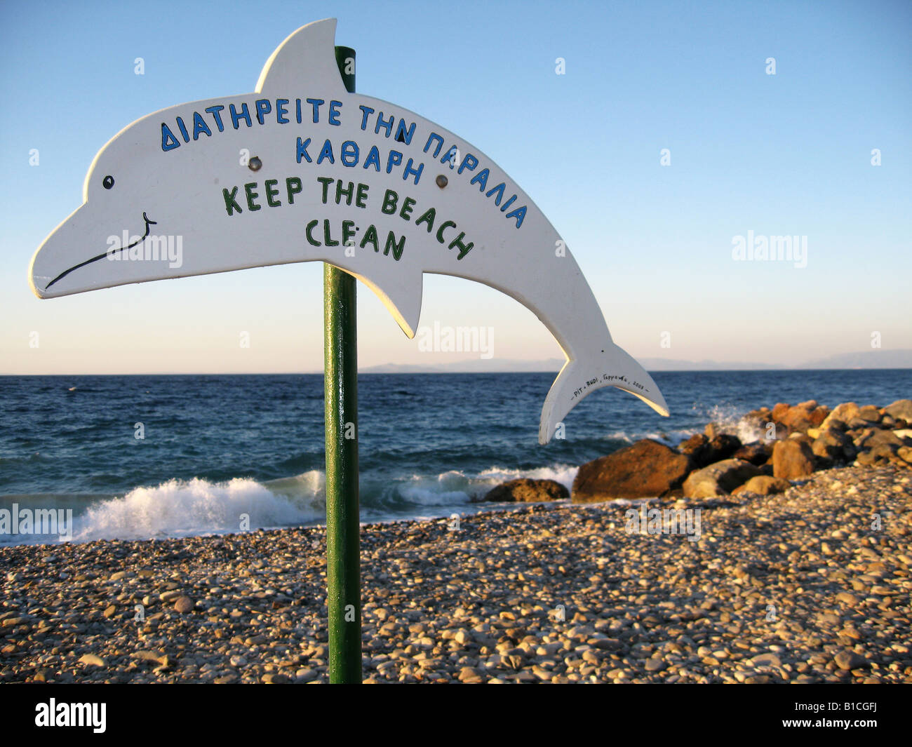 'Keep the beach clean' sign in form of a dolphin on a beach near Ag. Konstantinos on Samos island in Greece Stock Photo