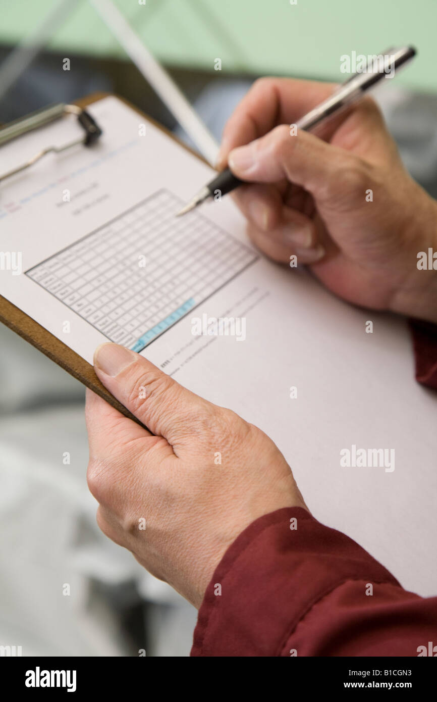 Senior worker holding clipboard Stock Photo - Alamy