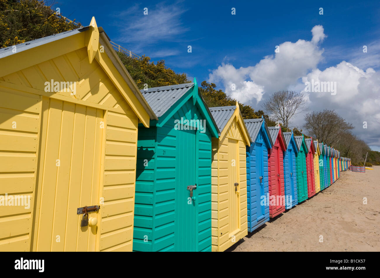 Multicoloured beach huts on the long sweeping beach of Llanbedrog LLyn Peninsula Gwynedd North Wales GB UK EU Europe Stock Photo