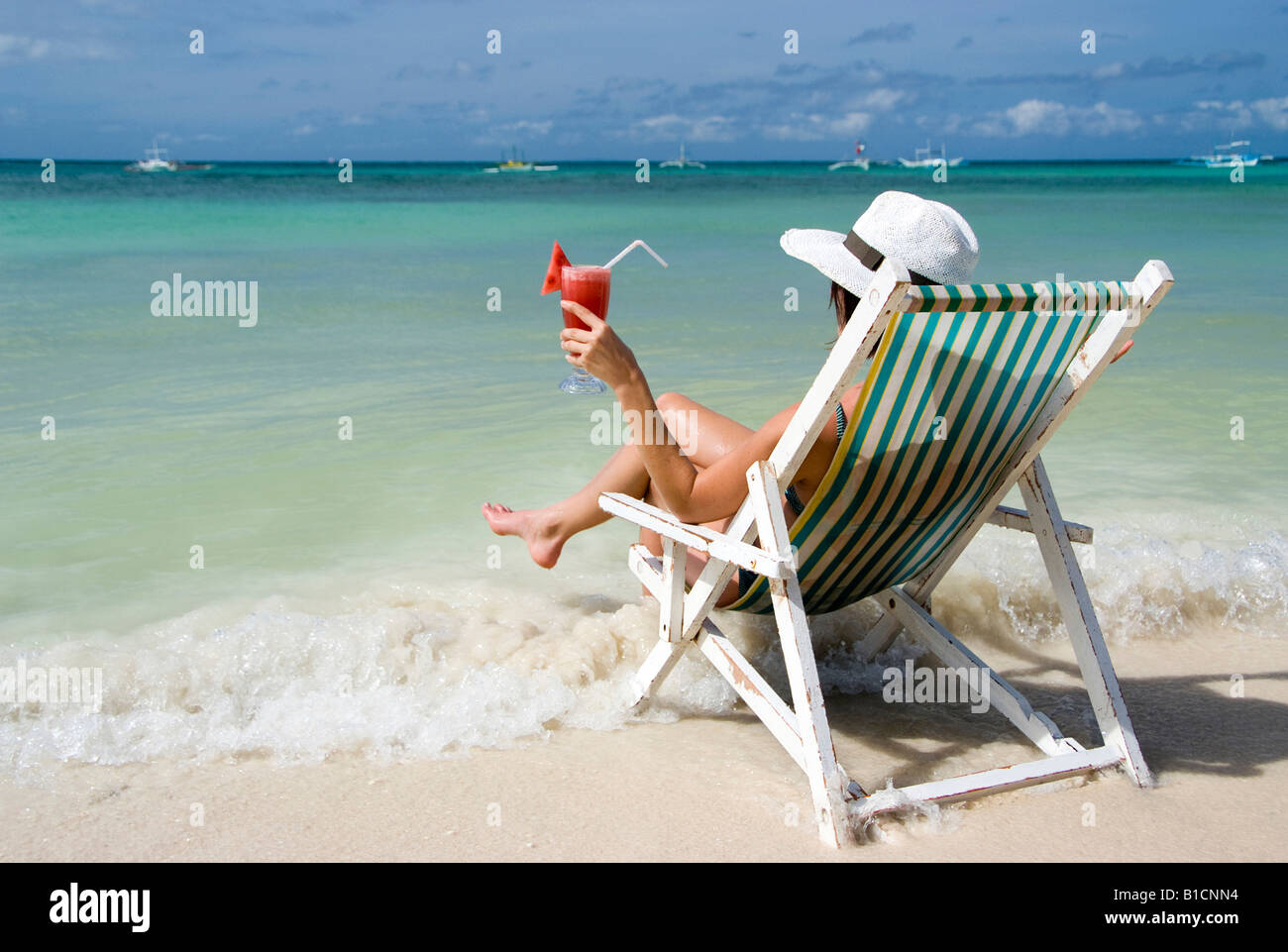 Woman With Cocktail Sits In A Folding Chair At The Beach