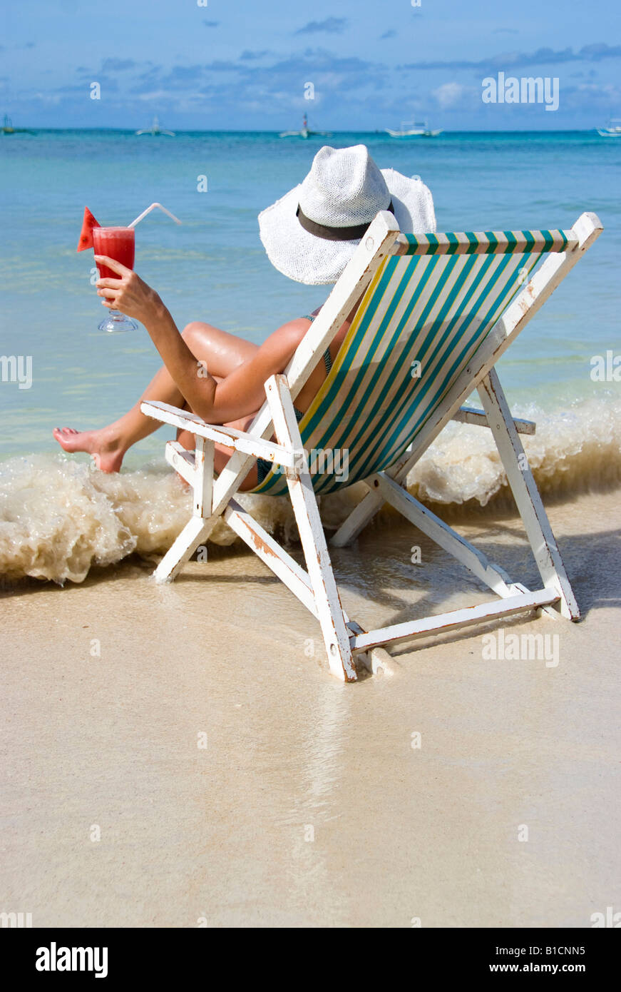 Woman With Cocktail Sits In A Folding Chair At The Beach
