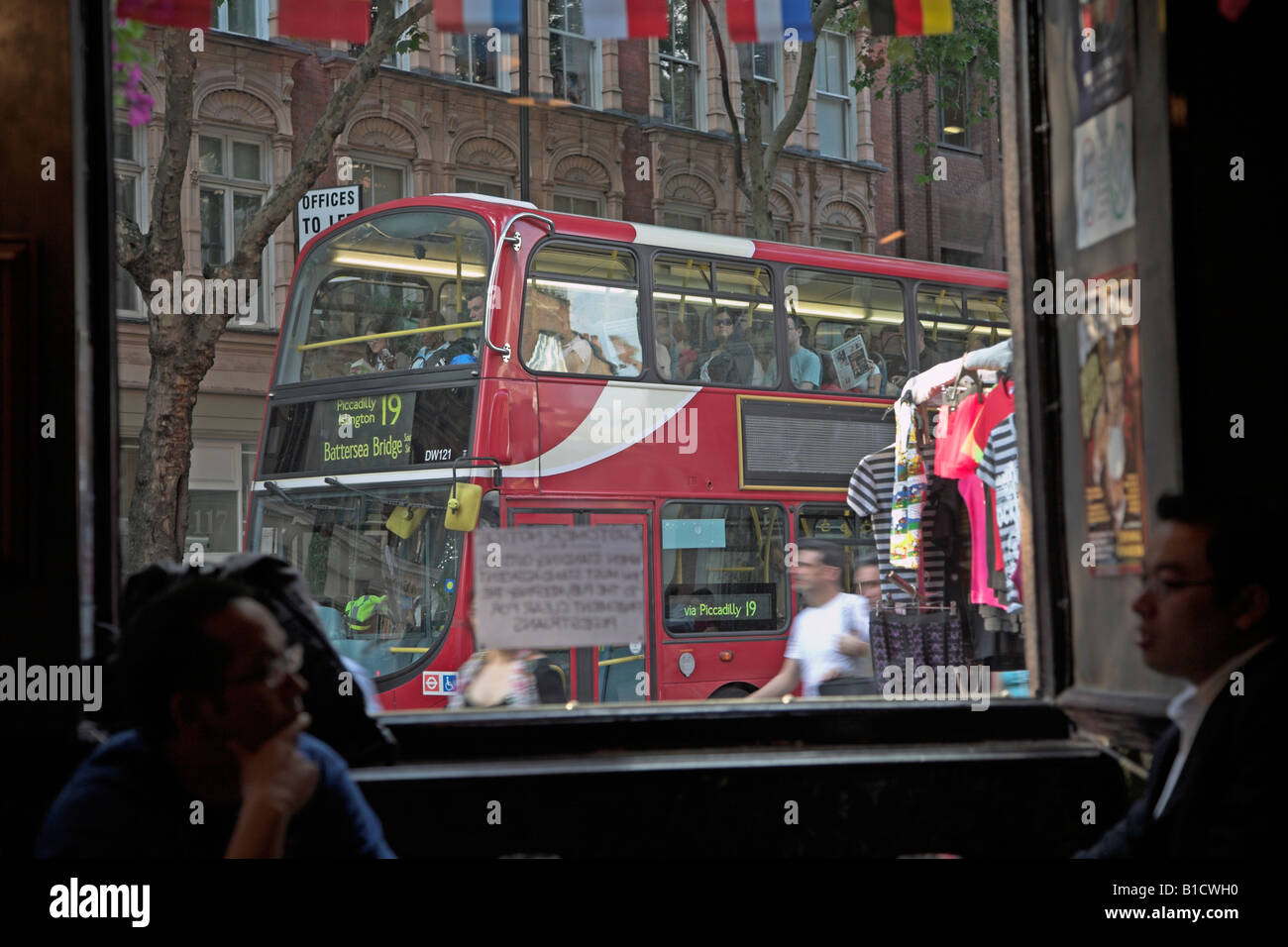 Red double decker bus busy street scene framed by window, central London, England Stock Photo