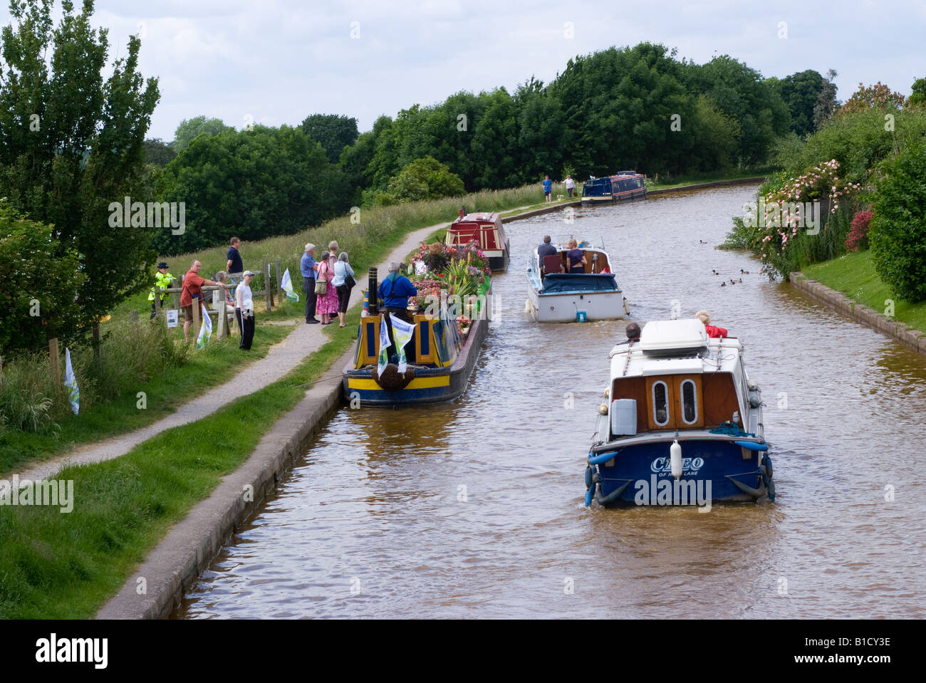 Two Holiday Pleasure Boats Pass Narrow Boat Decked in Flowers Going to
