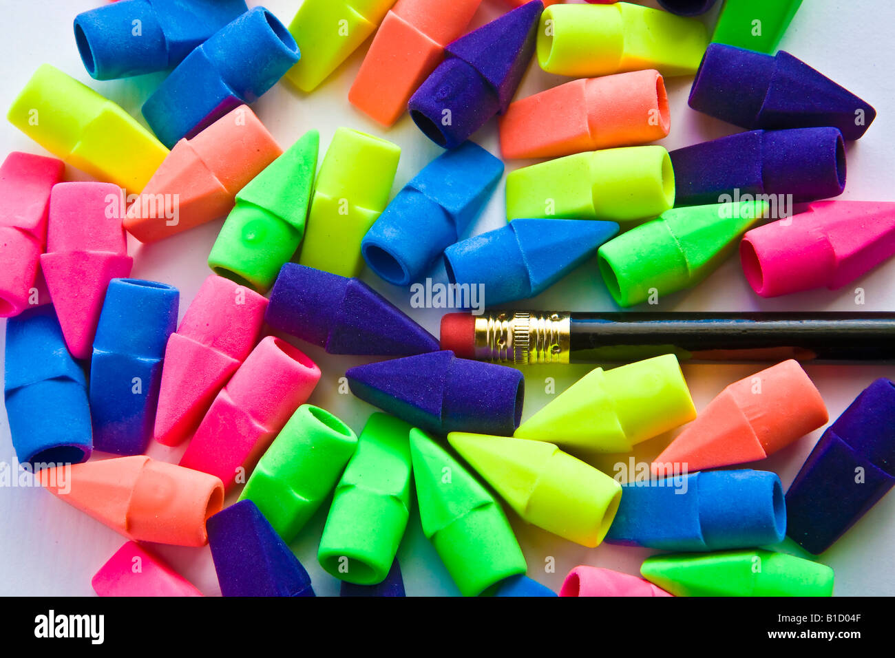 Pile of multicolored pencil erasers with black pencil on white
