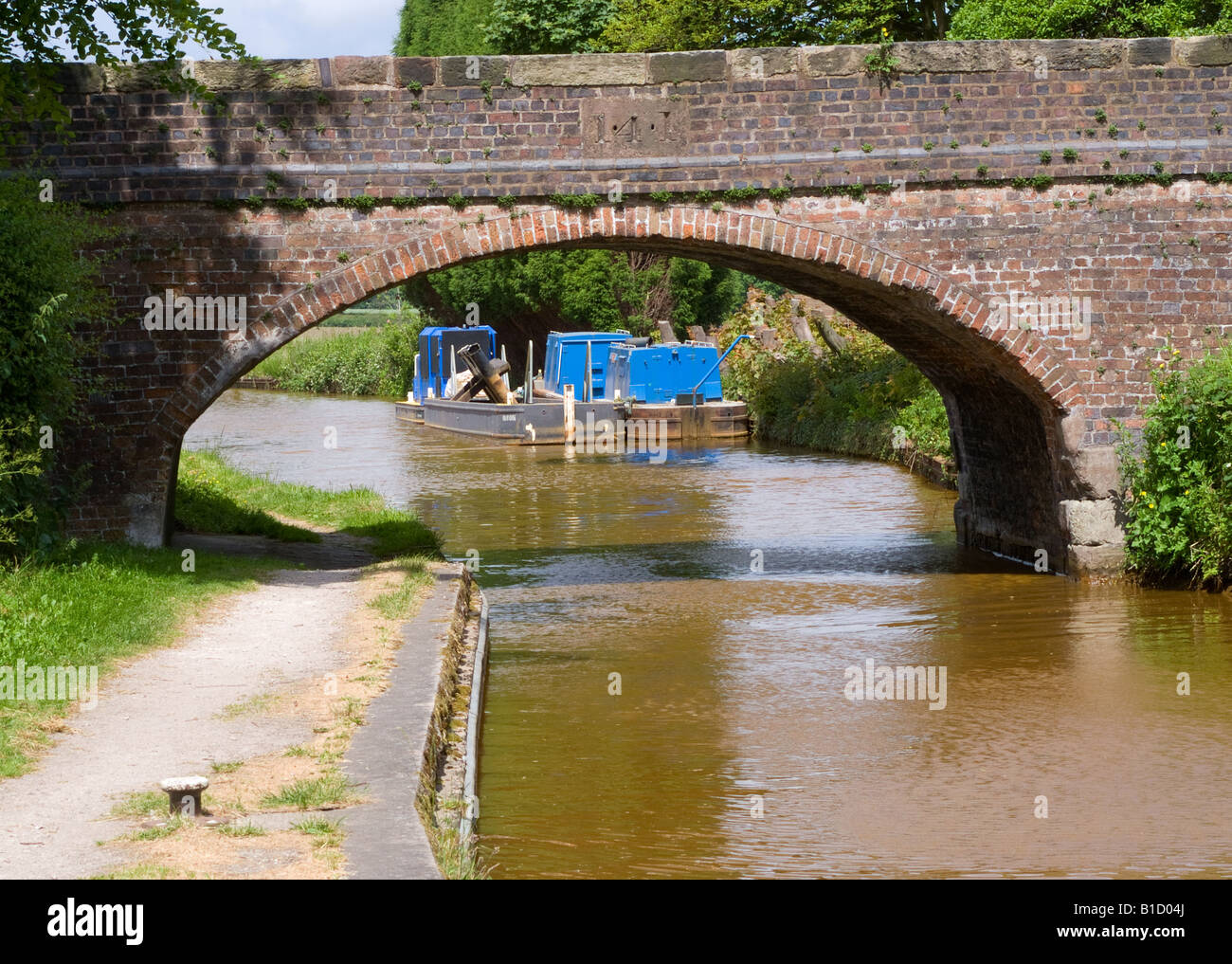 British Waterways Work Barges Moored on the Trent and Mersey Canal near Bridge at Rode Heath Cheshire England United Kingdom UK Stock Photo