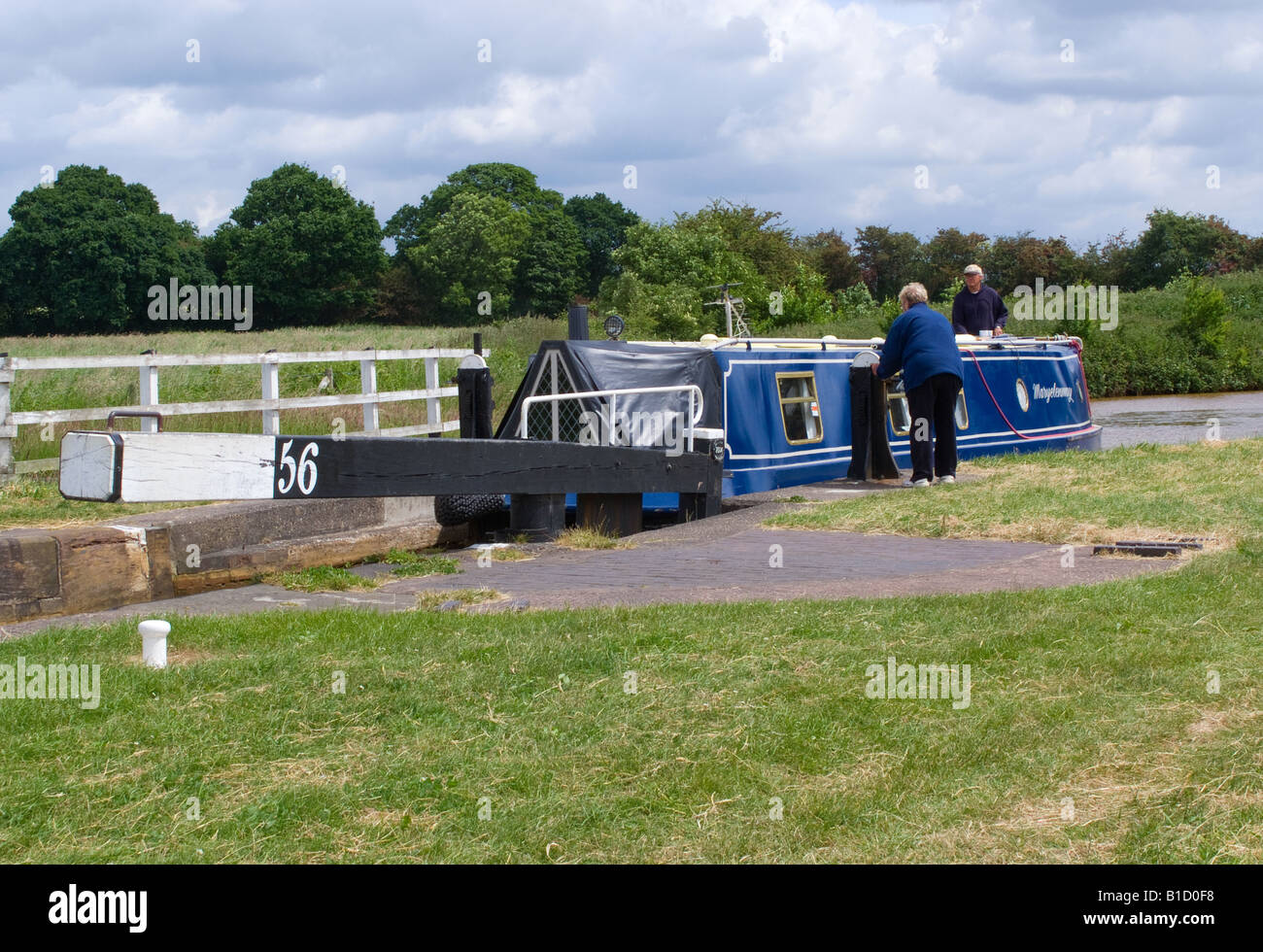 Older Retired Couple on Narrow Boat Entering Lock 56 On Trent and Mersey Canal Near Rode Heath Cheshire England United Kingdom Stock Photo