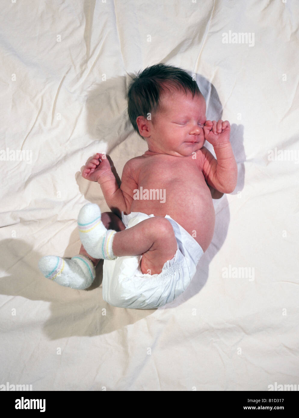 A newborn baby in a diaper asleep on her blanket Stock Photo Alamy